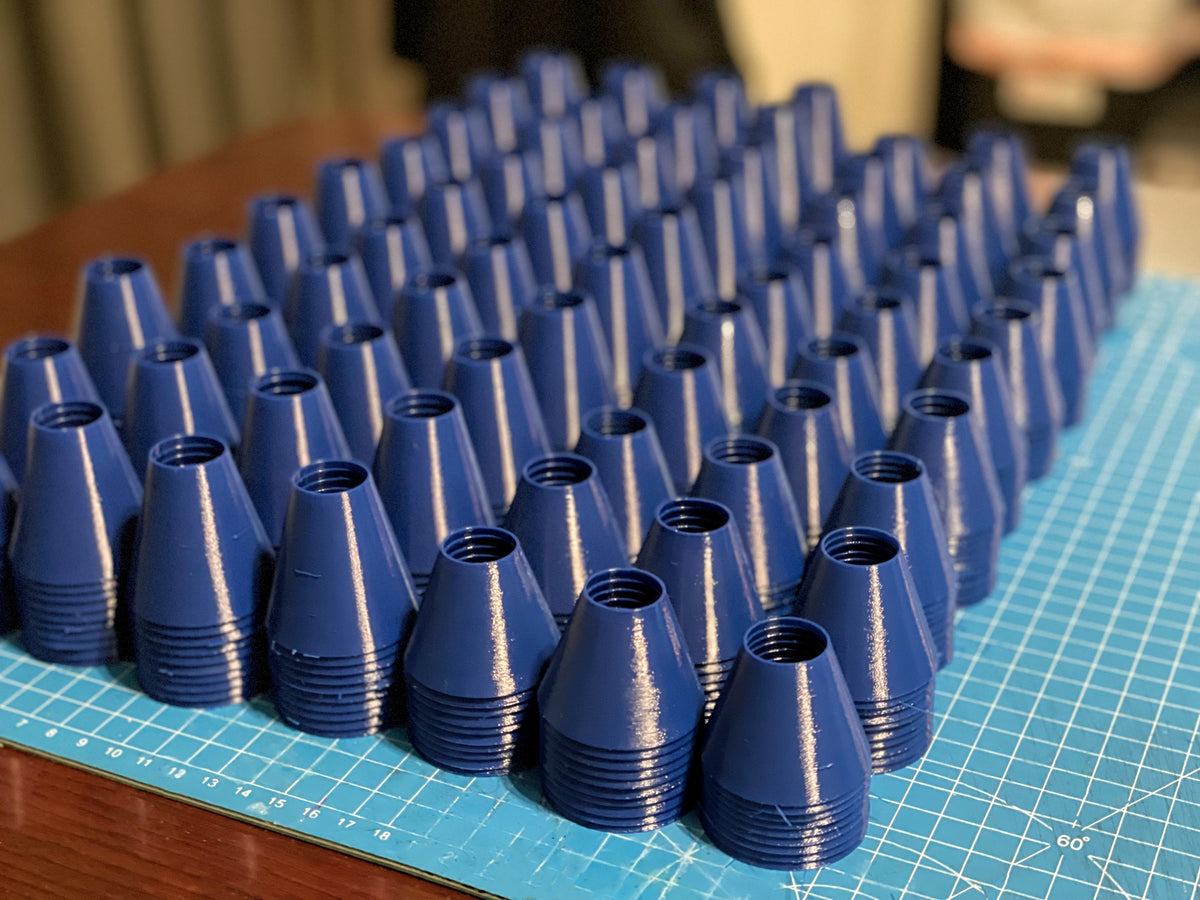 Rows of blue 3D-printed golf tees on a gridded mat